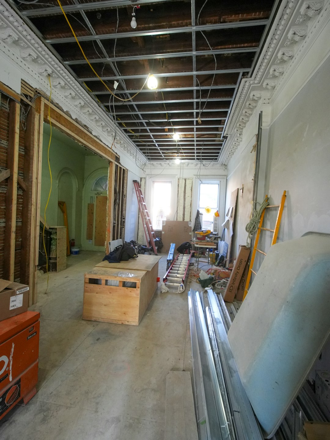 A three-story brownstone stands in mid-transformation, captured at the raw and honest “before” stage of a full interior renovation. These images document a moment that usually disappears once the walls are closed and the finishes are installed — exposed framing, stripped ceilings, rough staircases, and open corridors that reveal the building’s original structure and hidden history. Light spills in through skylights and tall windows, cutting through layers of dust and unfinished surfaces, creating a quiet contrast between decay and renewal. The space feels both industrial and intimate: narrow